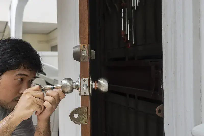 Residential locksmith performing a lock rekeying service for enhanced home security.
